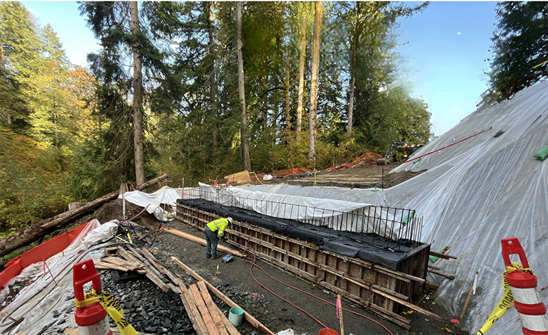 A crewmember inspects the foundation for the northern abutment wall