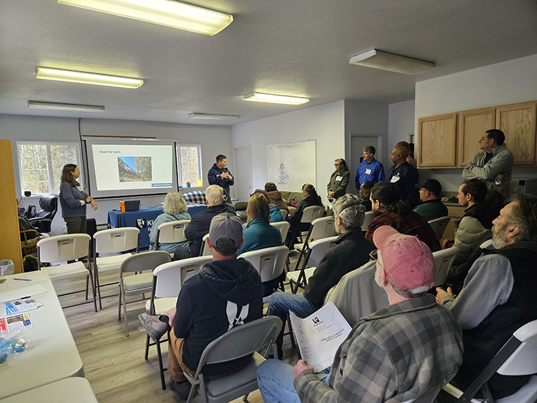People sitting in chairs during community meeting