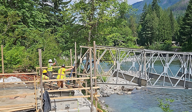 Maintenance crew working on bridge at edge of water