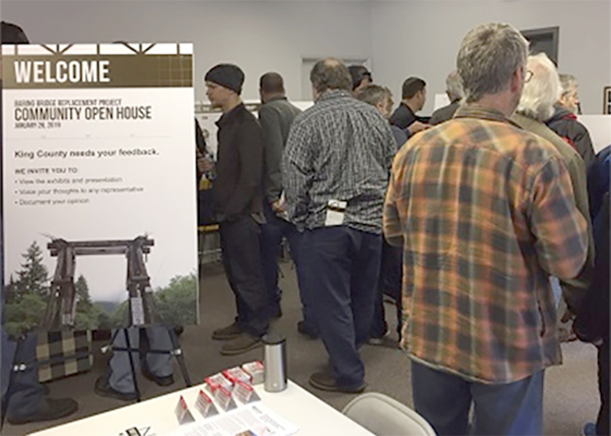 People in room attending open house meeting.