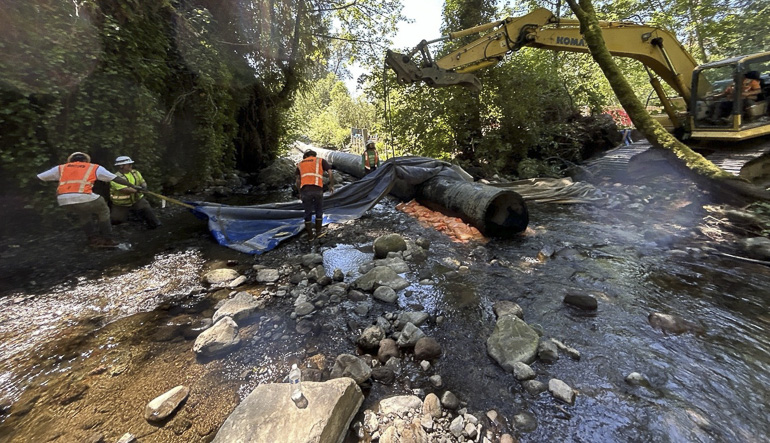 Construction workers making aqua damn in stream
