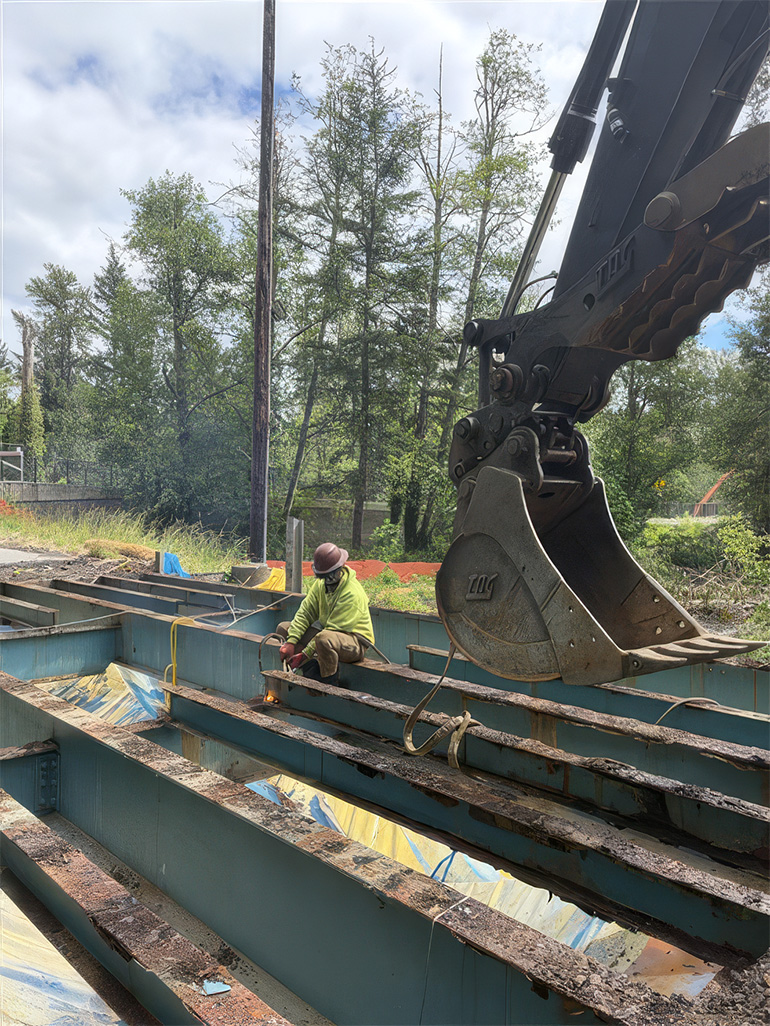 Crew member working on old metal bridge