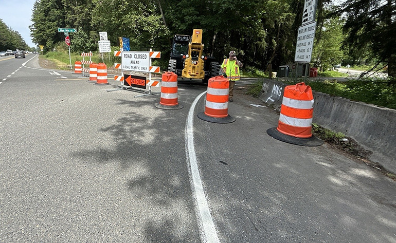 Construction sign and barriers blocking road.