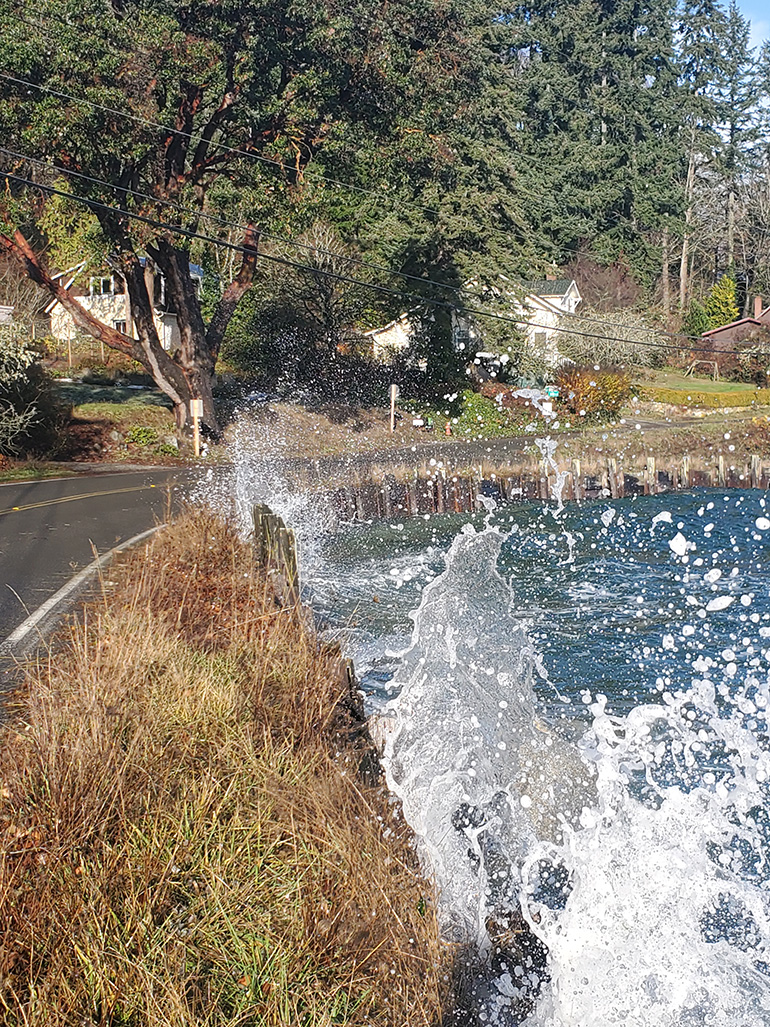 Waves splashing against the seawall and roadway on Dockton Road SW.