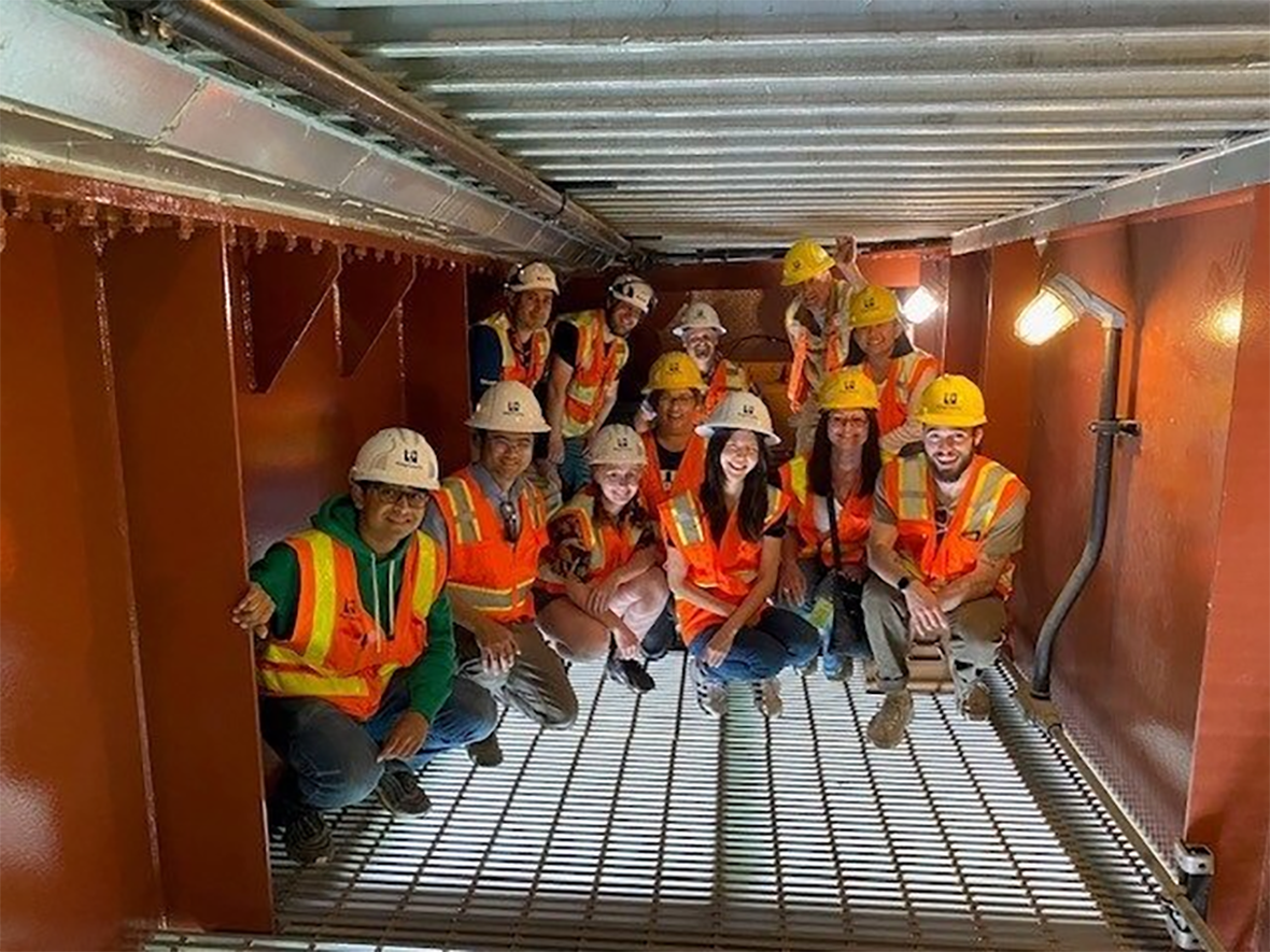 Interns pose for a photo inside the underworkings of the South Park Bridge.