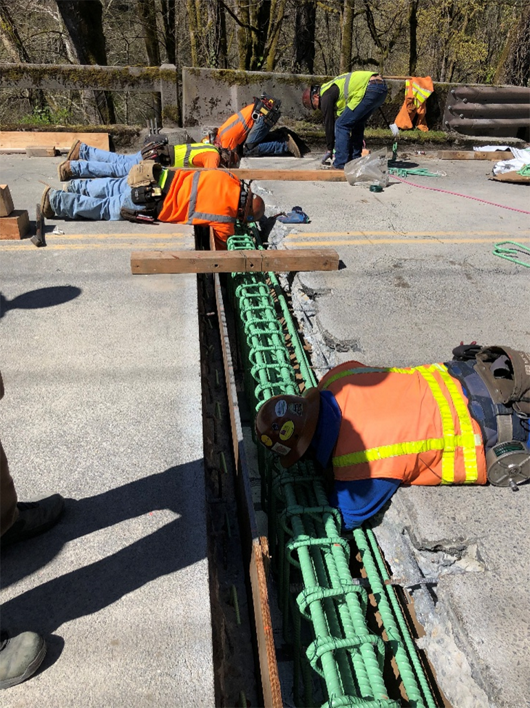 Contractor crews working for King County rebuild a section of the bridge deck .