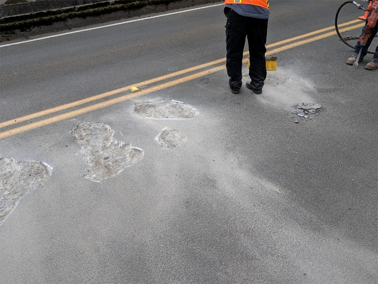 Crews chip out and clean potholes.