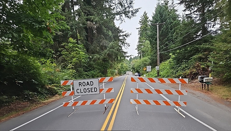 Road closed signs blocking road