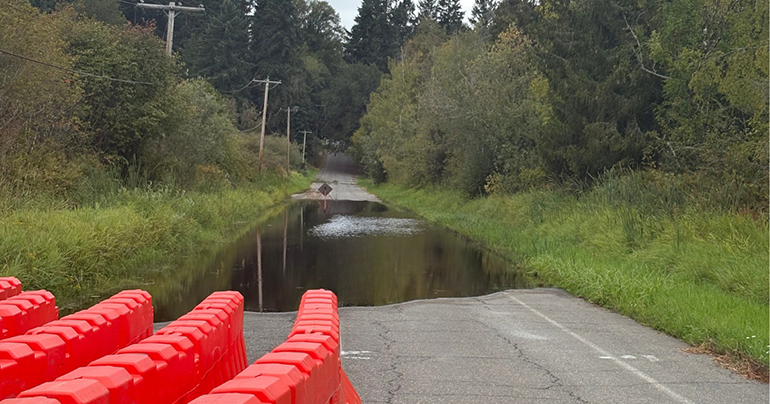 Orange road barriers near water over road