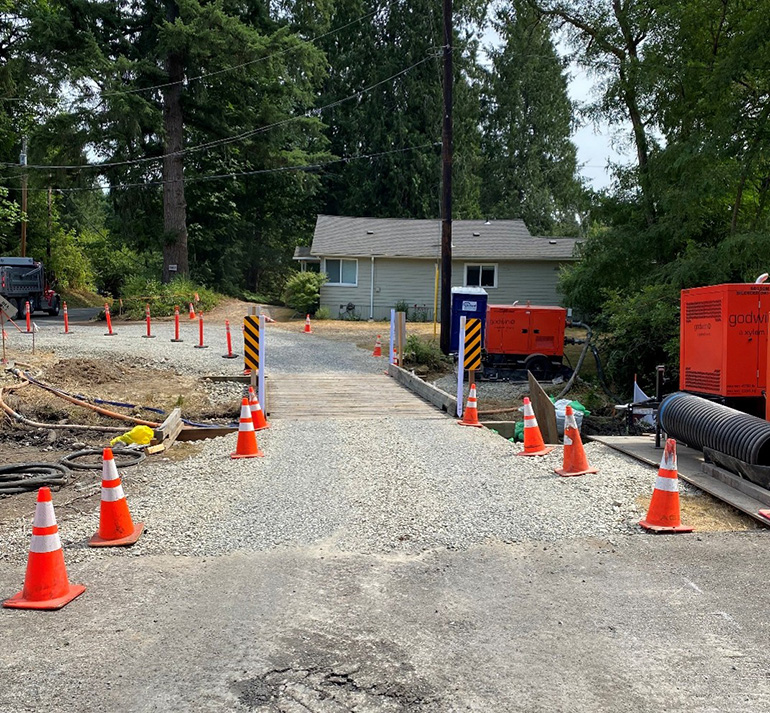 A a temporary one lane gravel bypass road which includes a wooden bridge. 