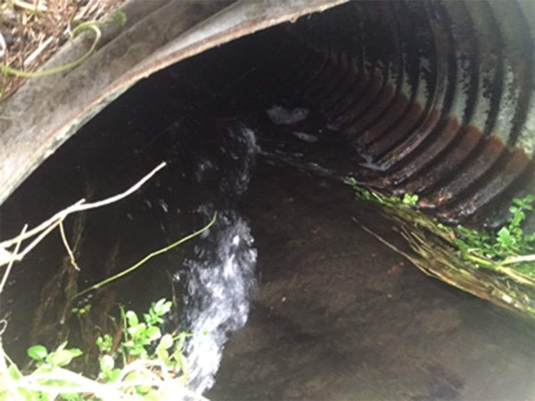 Water flowing through metal pipe.