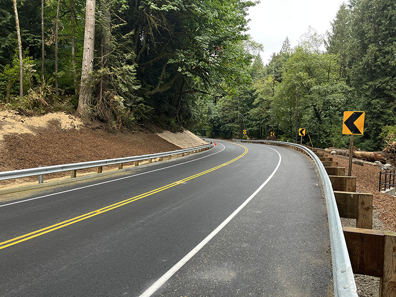 Smooth surface of freshly paved section of NE Woodinville Duvall Road above the new concrete box culvert. 