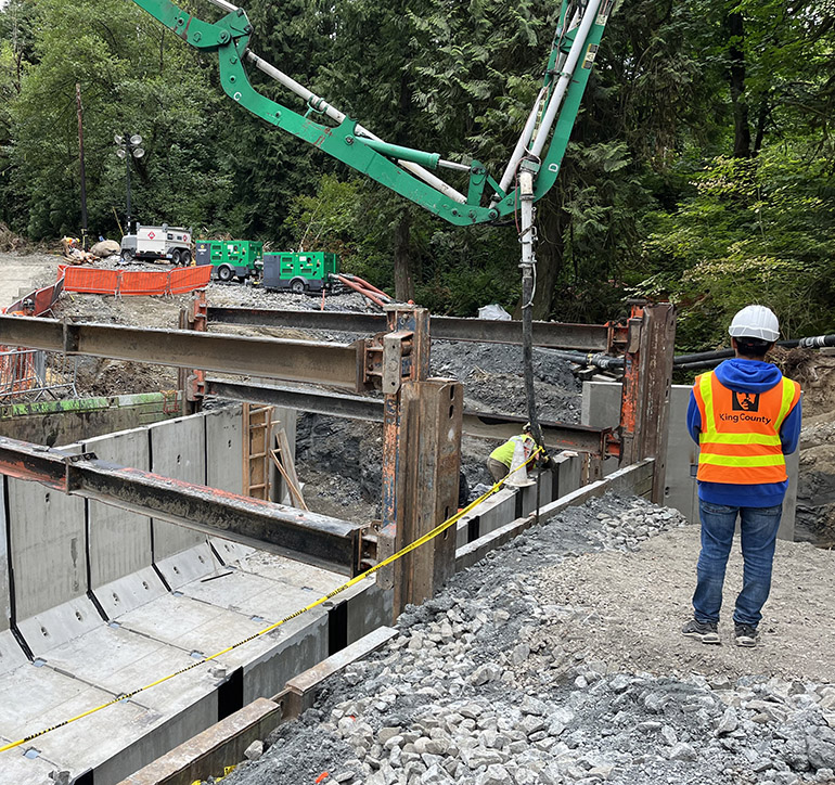 Culvert concrete is carefully poured between wall sections of the new culvert to secure them in place and prevent leaks.