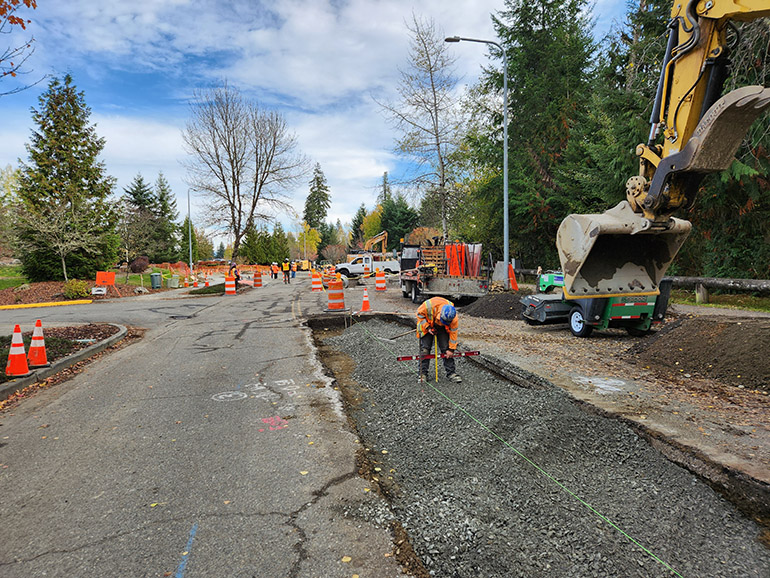 A crew member takes more measurements to ensure that after the grinding, the remaining hot mix asphalt (HMA) thickness is the King County standard. 