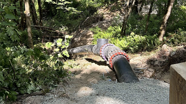 Sturdy pipe coming out of gravel under roadway