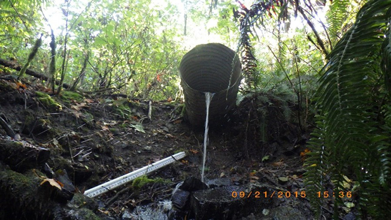 Culvert sticks out of soil, you can see that soil underneath has eroded and fallen away.