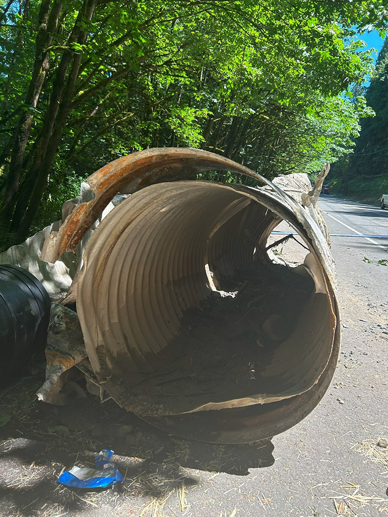 Old, worn-out pipes lay on the road after removal.
