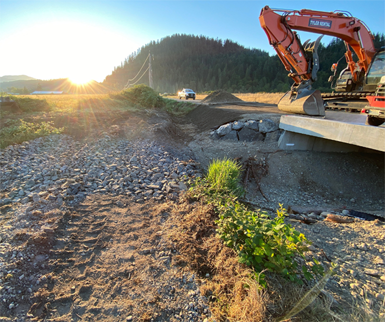 New box culvert with the road built back and fresh pavement.