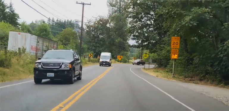 Vehicles driving along road.