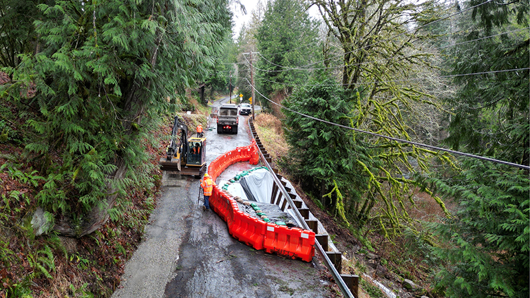 Aerial viewlokingdown on construction barriers on gravel road with heavy machinery