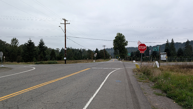 All-way stop signs at the intersection of SE Green Valley Road and 218th Ave SE/212th Way SE. 