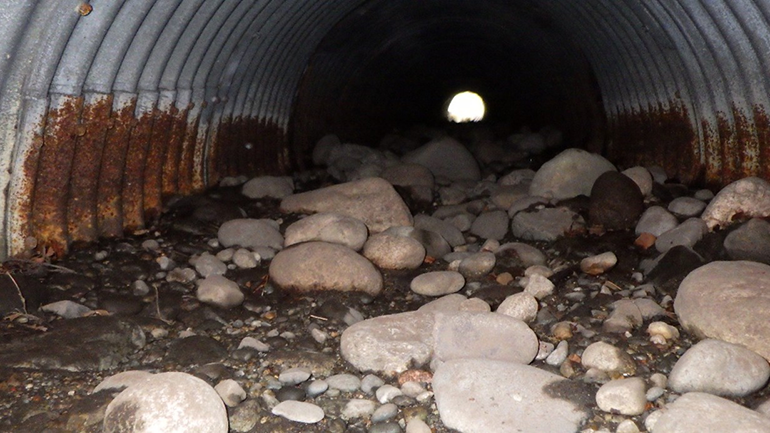 Inside of culvert filled with large rocks and dirt