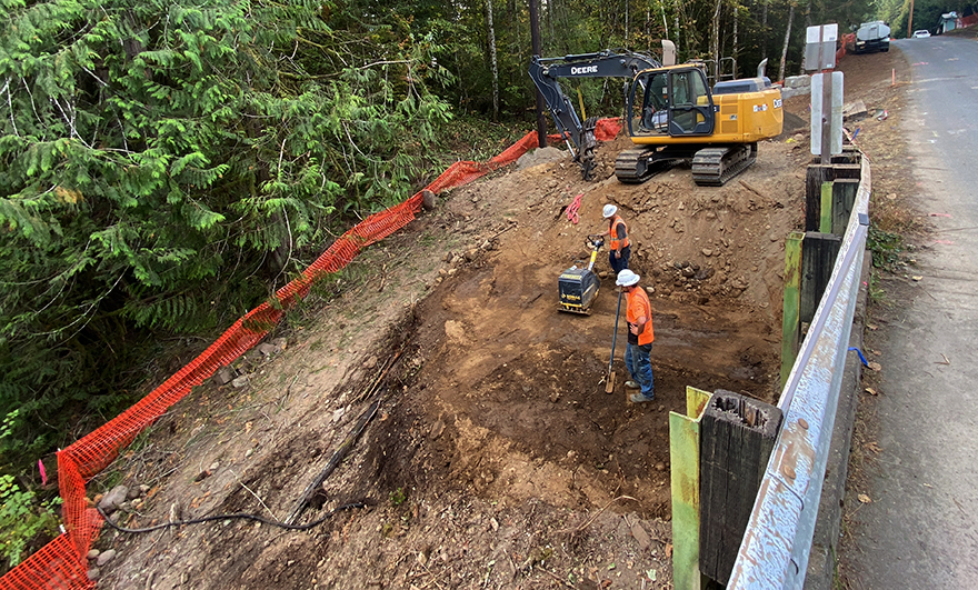Oct. 4, 2022 – Two crewmembers compact soil in preparation for the concrete abutments for the temporary bridge