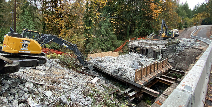 Nov. 8, 2022 – Two excavators tear down the old bridge during demolition.