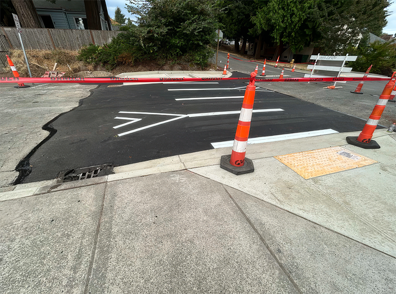 New asphalt and white paint stripes in road.