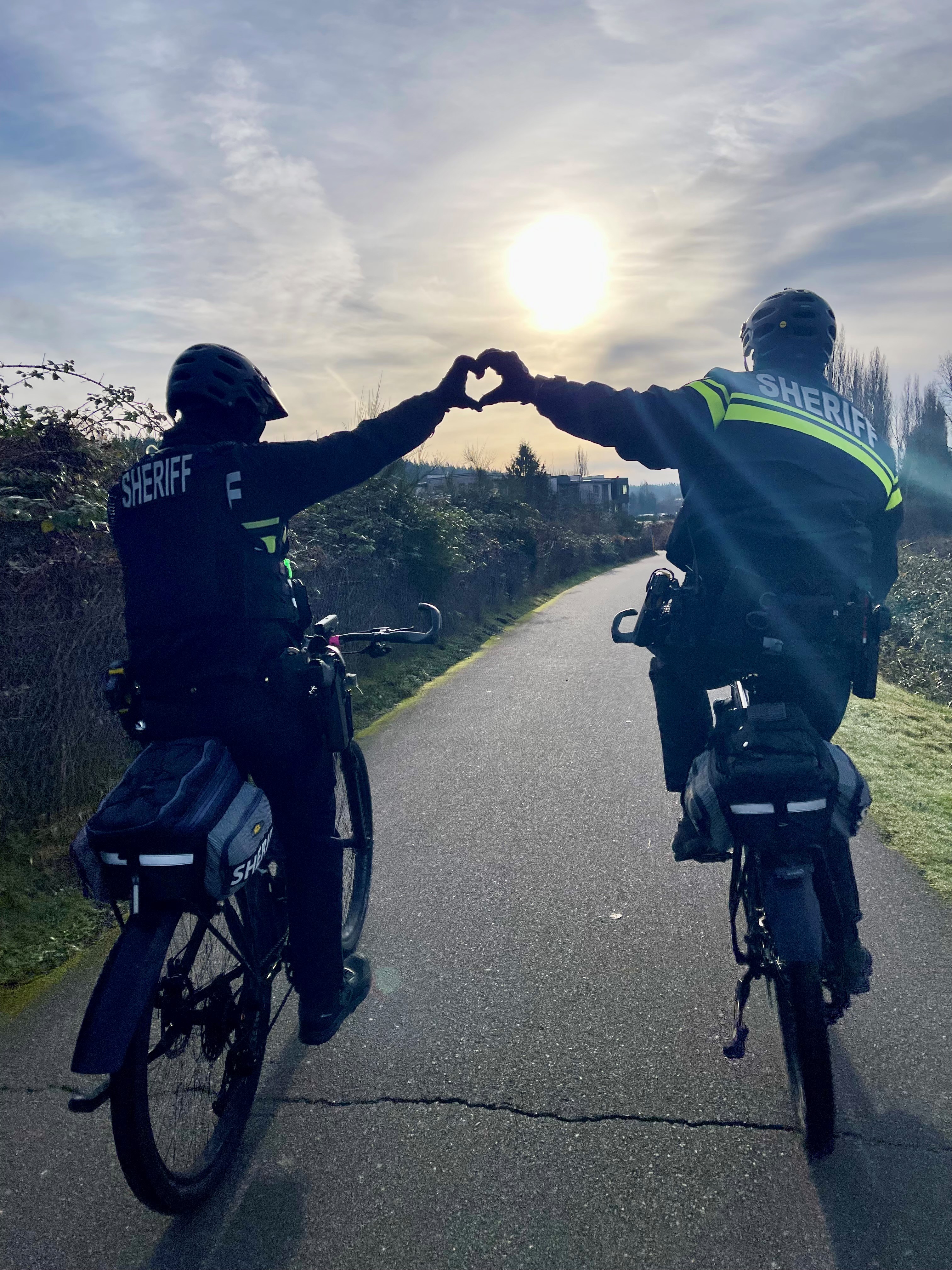 Deputies on the BEES, making heart hand gesture in front of sunset