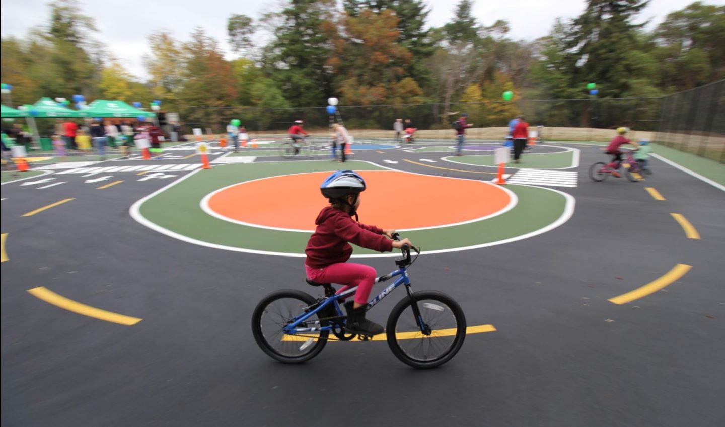 Children ride bikes around the bike playground at Dick Thurnau Memorial Park in White Center