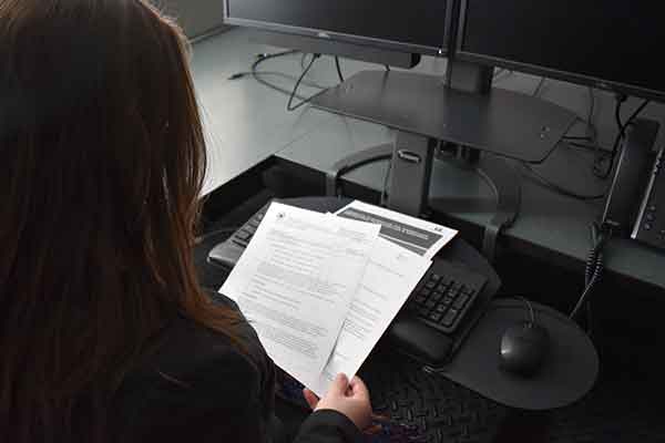 Woman sitting at desk reading Domestic Violence in the Workplace policy