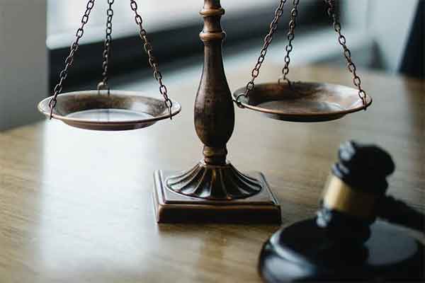 Closeup of wood desk with scales of justice and gavel