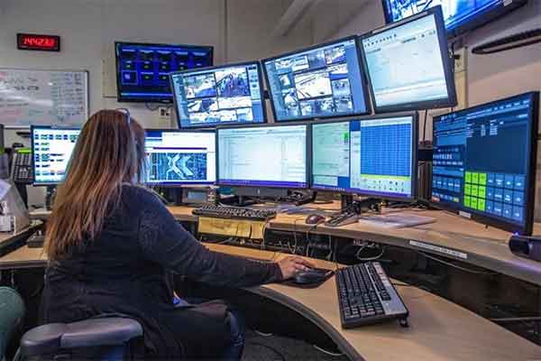 A 911 call operator in front of multiple computer monitors
