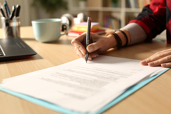 Student girl hand signing contract at night