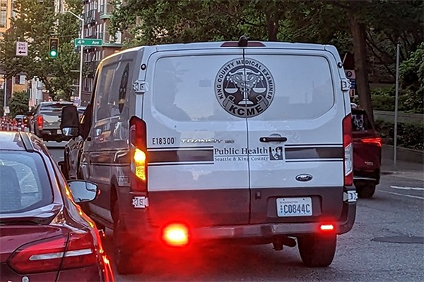 Back view of of KCME van driving down a street.